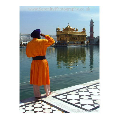 A safron-robed guard patrols the Golden Temple in Amritsar, India.